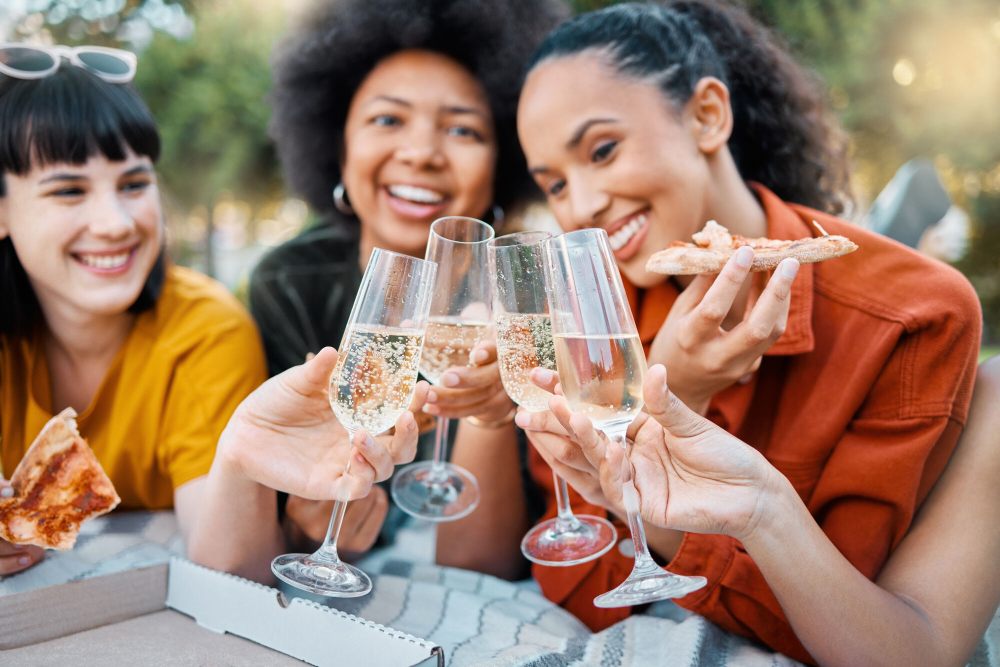 A group of friends enjoying pizza and sparkling wines 