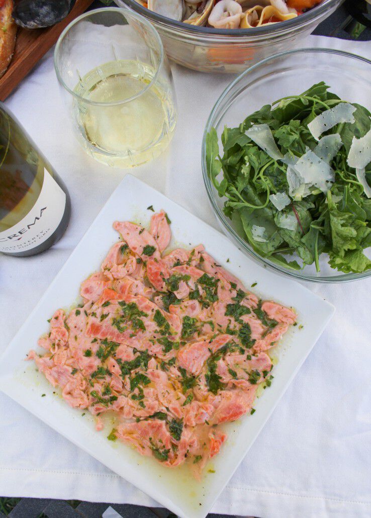 Salmon carpaccio with salad and white wine