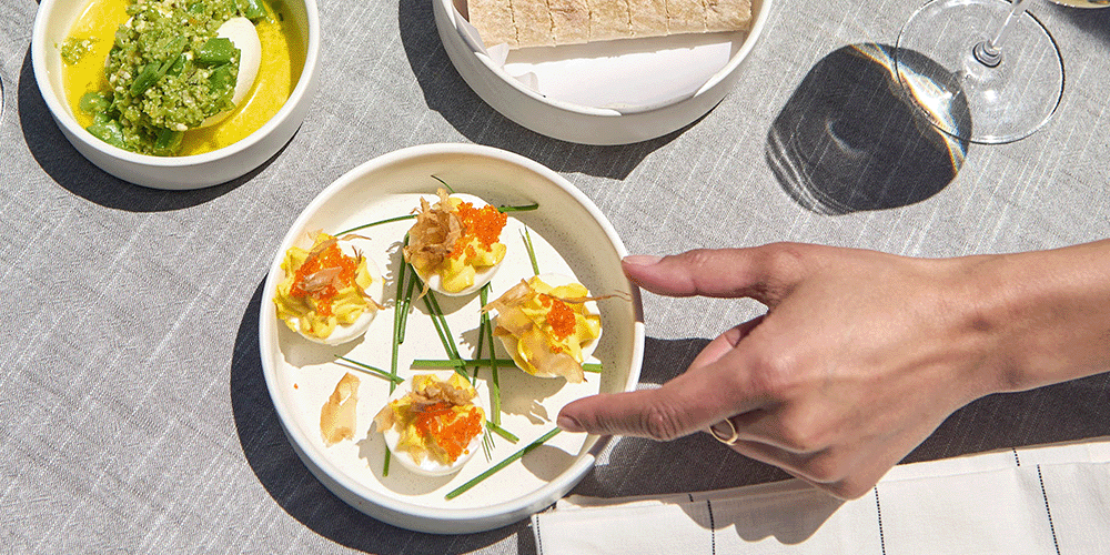 A person about to grab a deviled egg