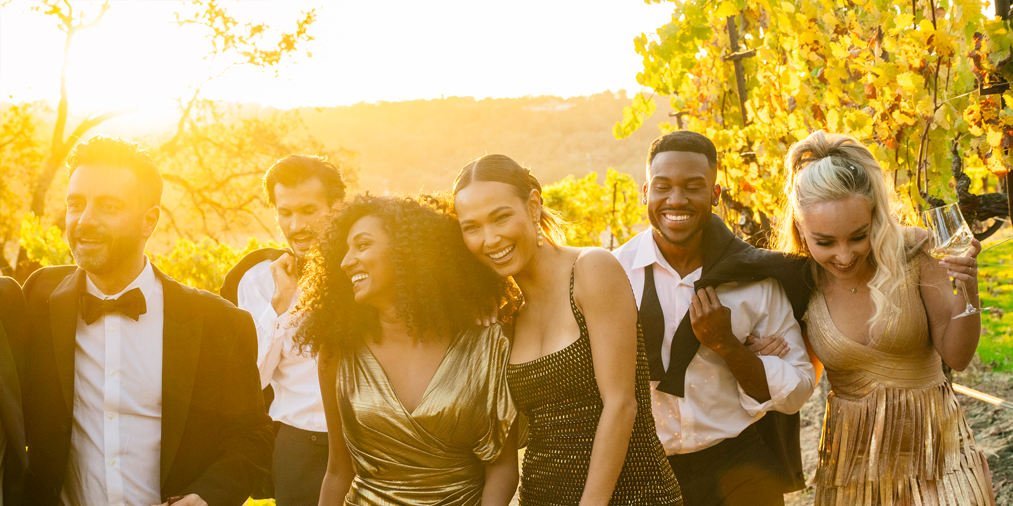 A group of friends, women and men, who are enjoying wine while walking through the La Crema Estate vineyard