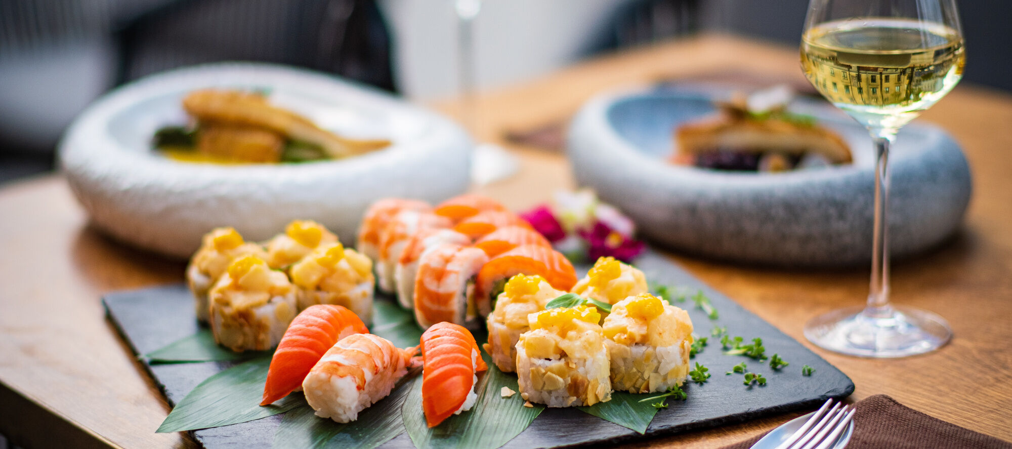 A plate of assorted sushi with wine