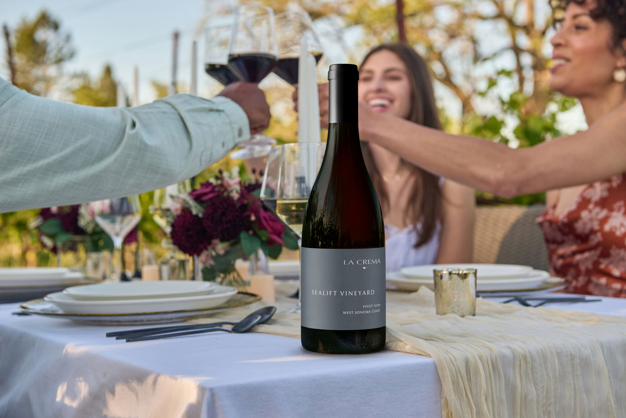 A group of friends enjoying La Crema Pinot Noir at outside table