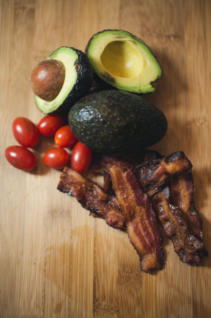 Bacon, avocado, tomatoes on a cutting board