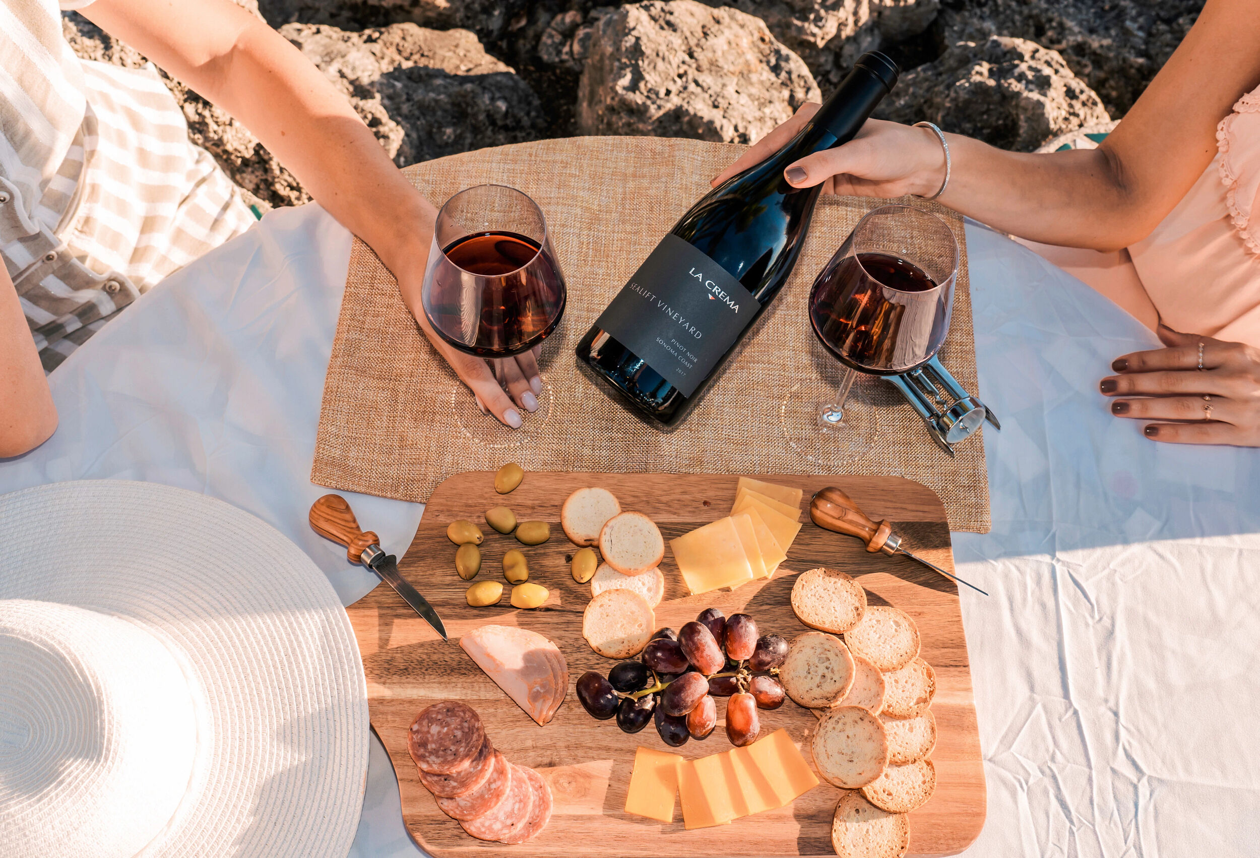 A charcuterie board with snacks and La Crema Pinot Noir
