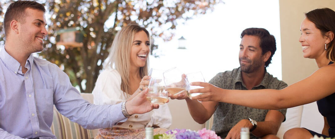 Group cheers wine glasses with white wine