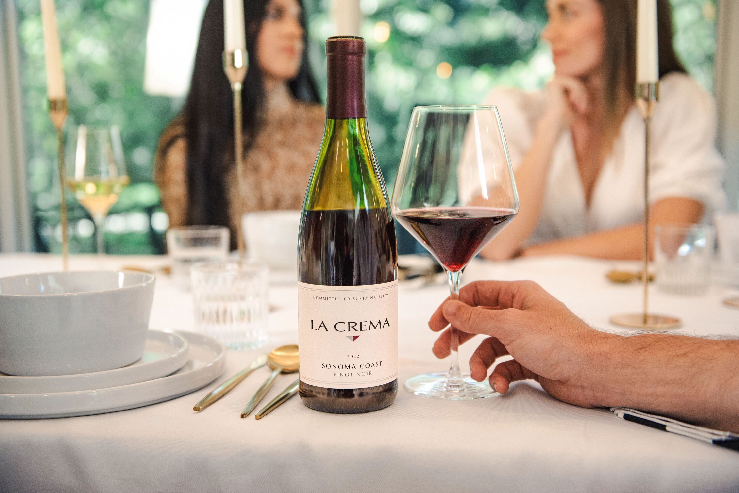 La Crema Pinot Noir wine at a table with friends