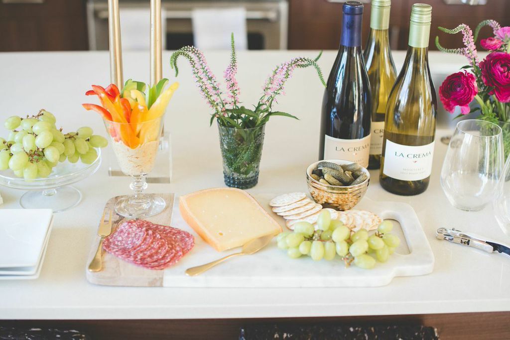 Charcuterie board and snacks with wine and flowers