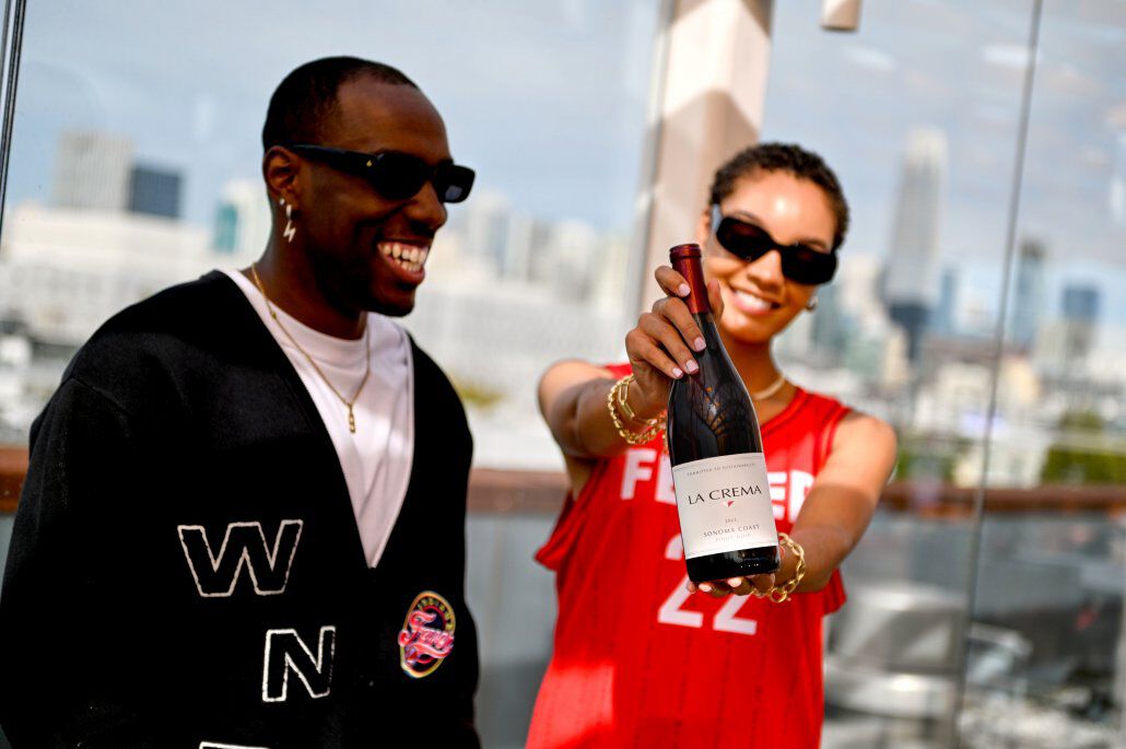 WNBA fans holding a bottle of La Crema Pinot Noir WNBA fans holding a bottle of La Crema Pinot Noir