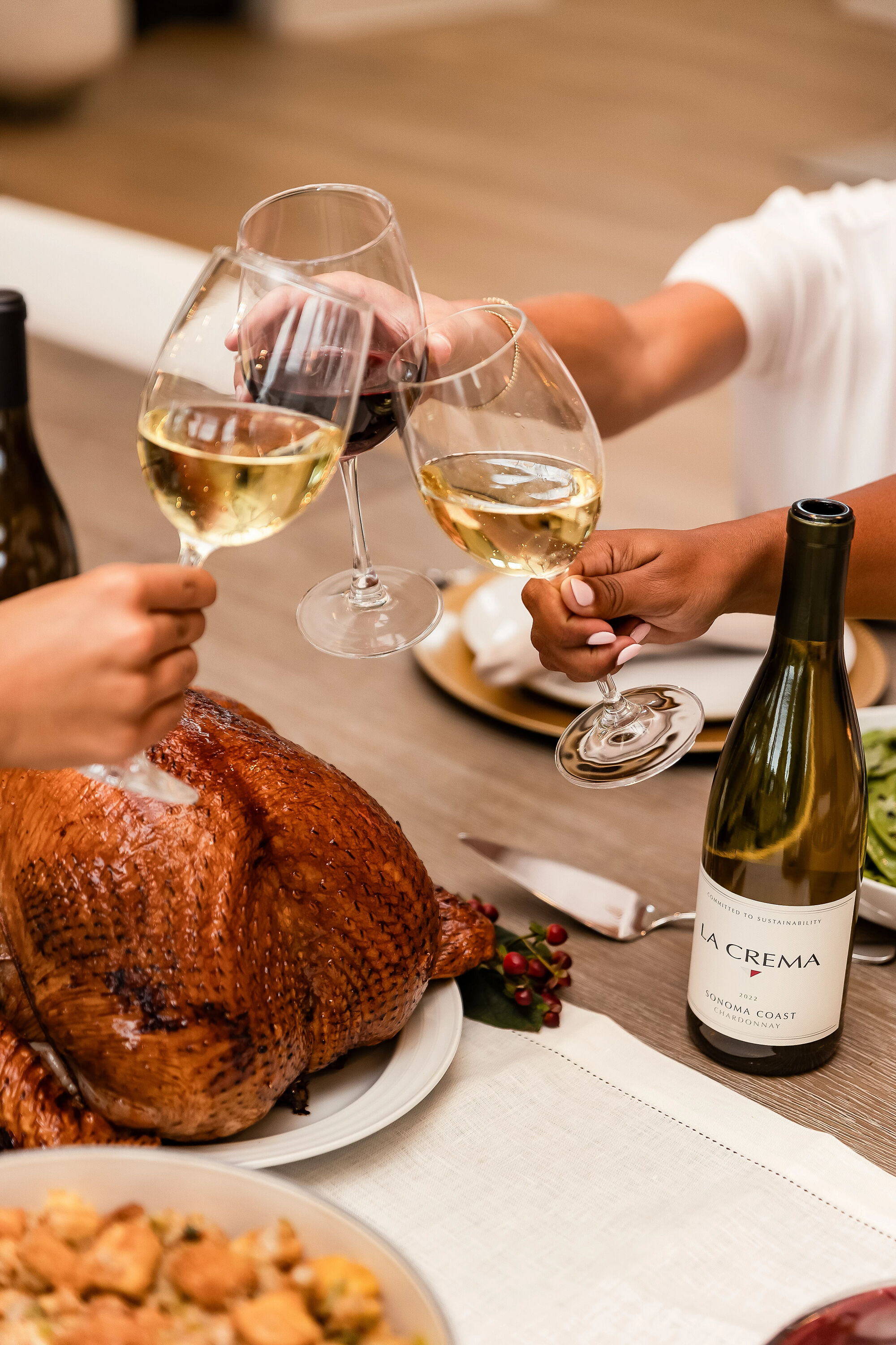 Friends toasting to a Thanksgiving meal with La Crema wine