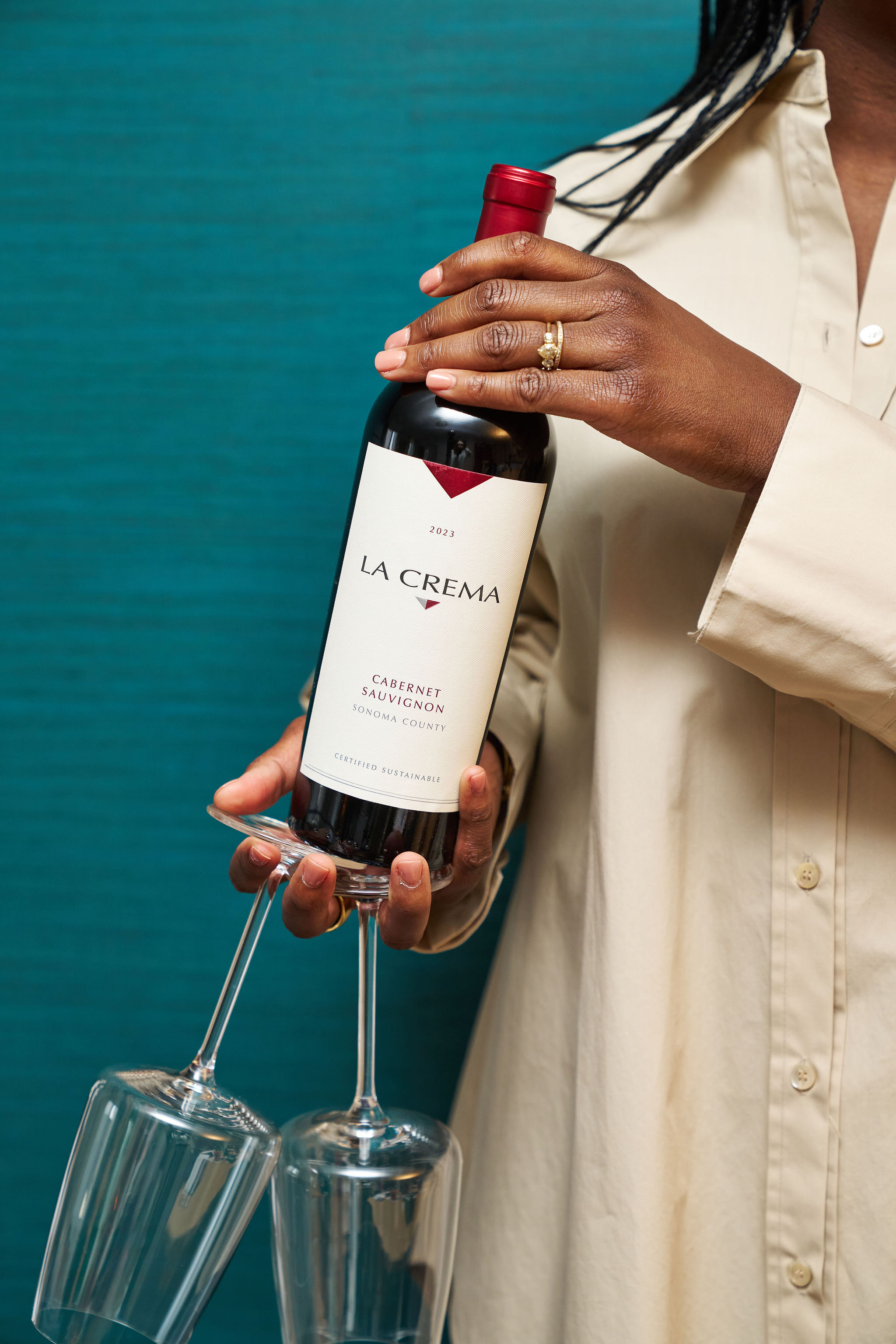 A person holding a bottle of La Crema Cabernet Sauvignon