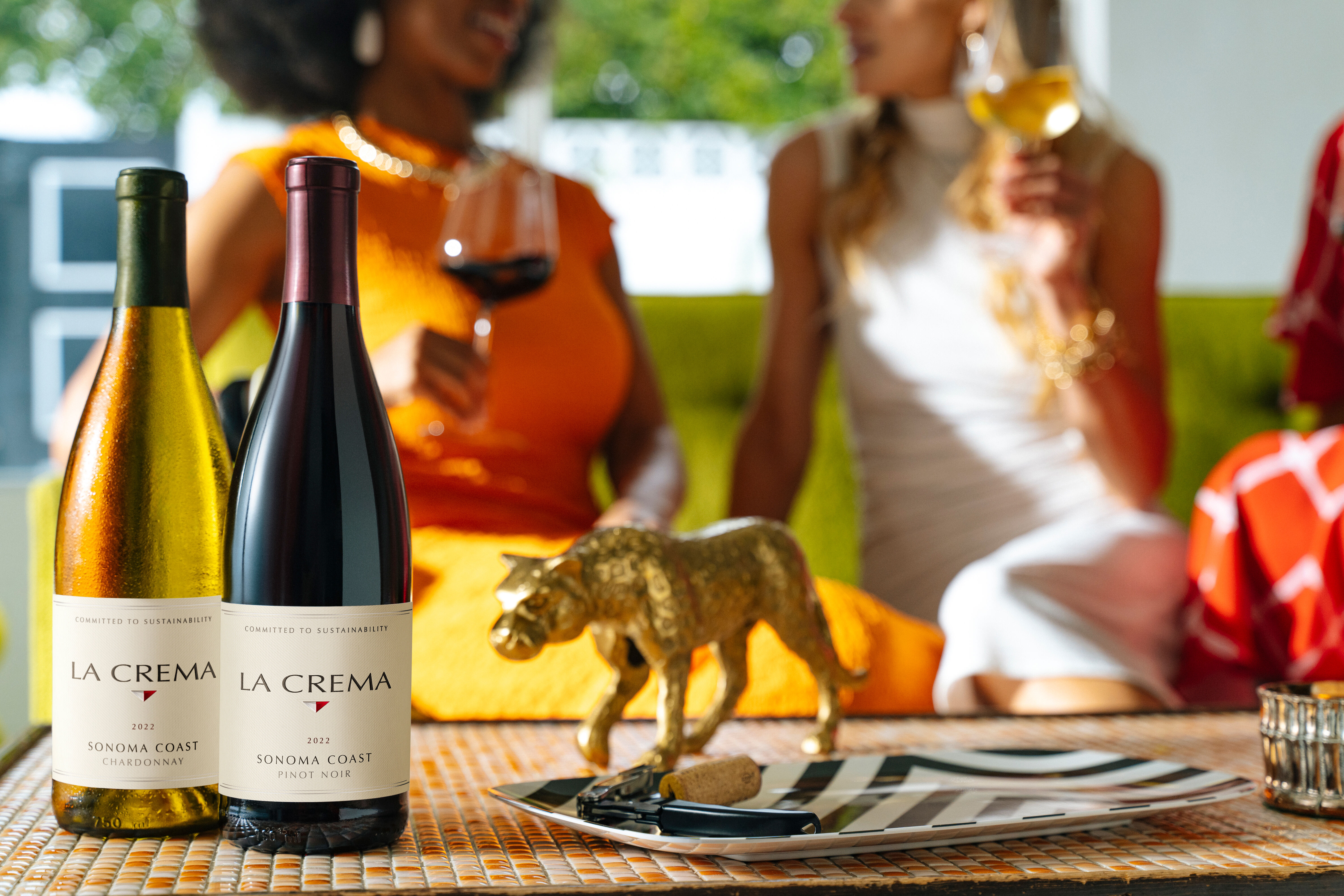 Friends enjoying wine with La Crema wine bottles in the forefront