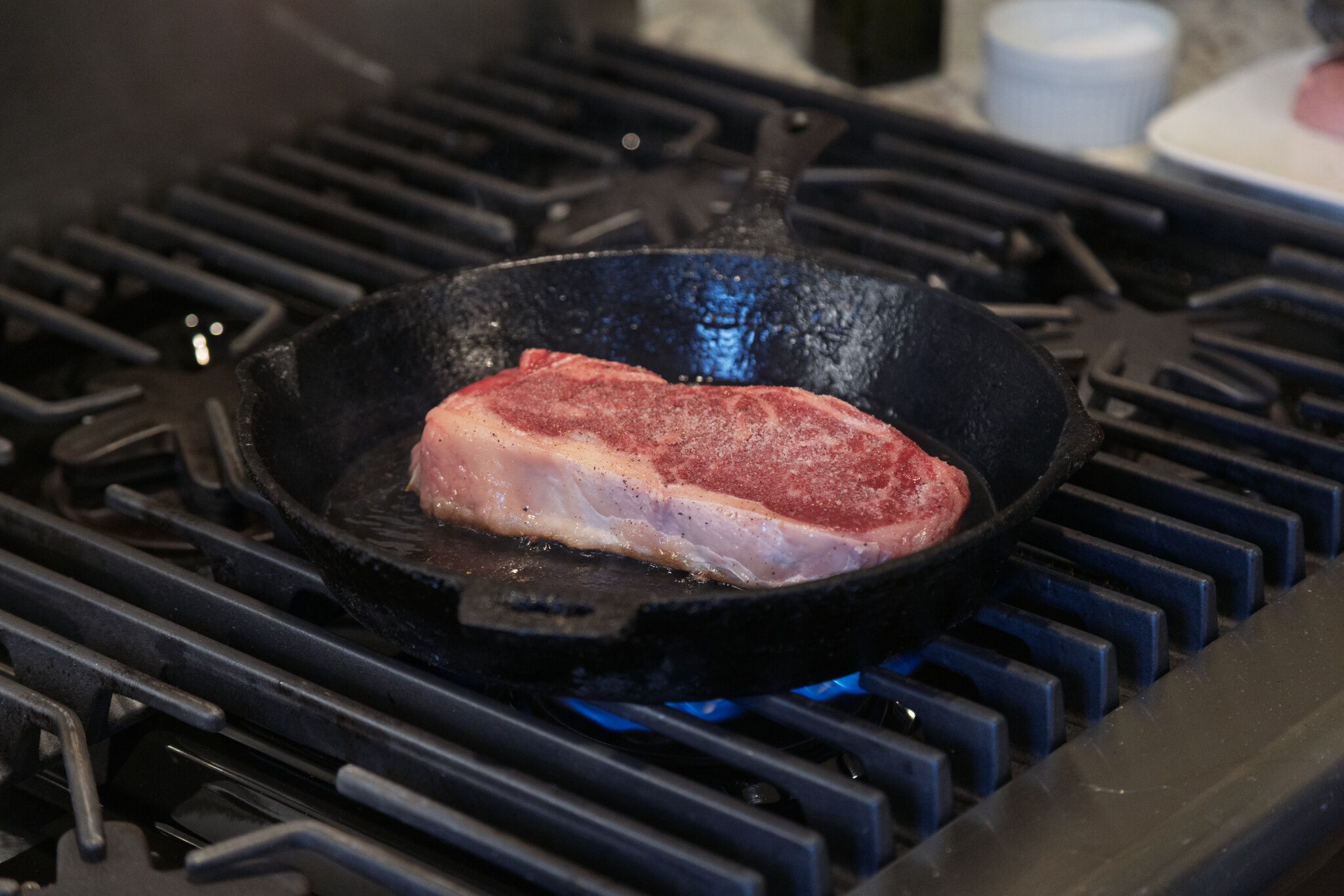 Raw steak cooking on a pan