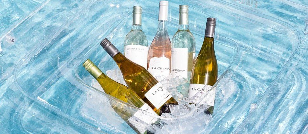 La Crema wine bottles in an ice chest in a pool