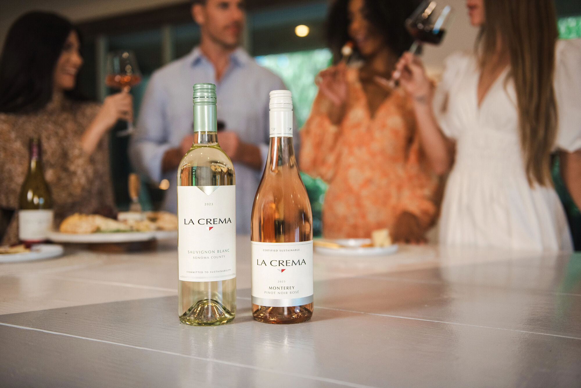 La Crema Sauvignon Blanc and Rosé being enjoyed by friends at a dinner party