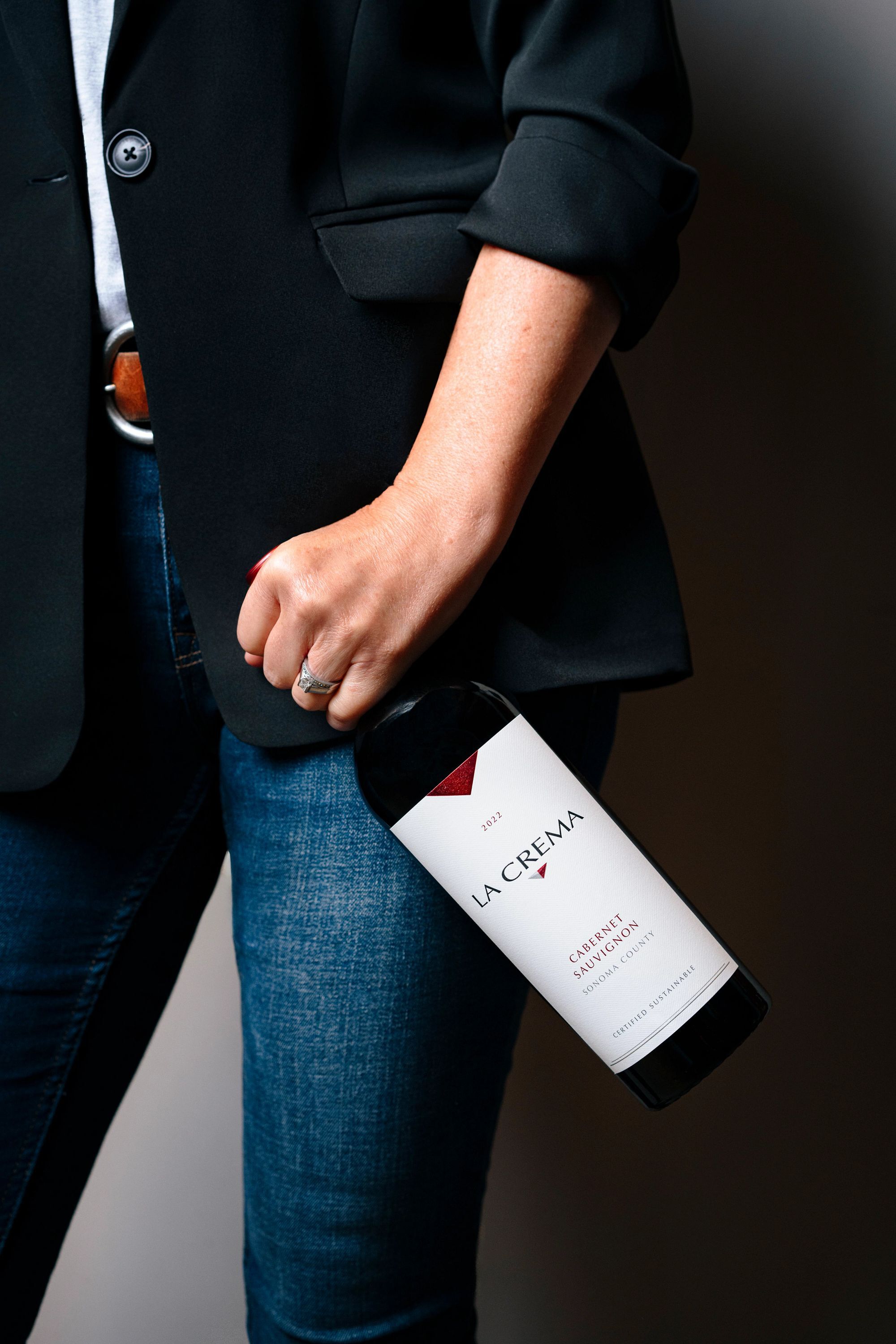 A person holding a bottle of La Crema Cabernet Sauvignon