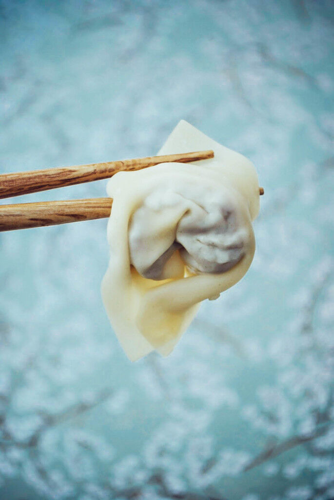 Wonton being held by a chopstick