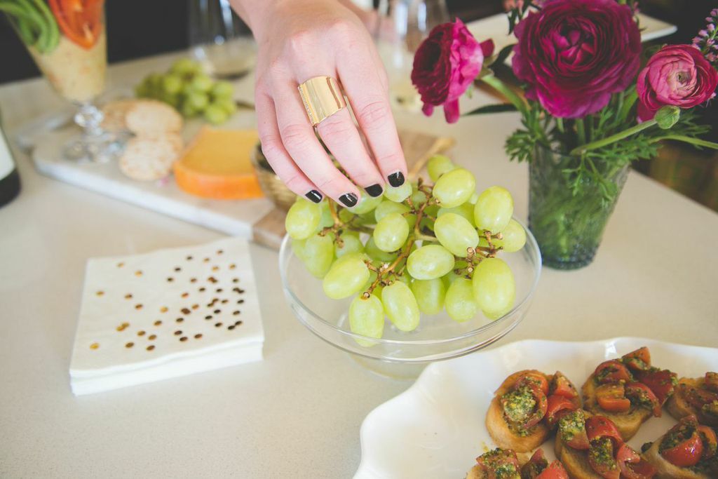 A hand picking some grapes