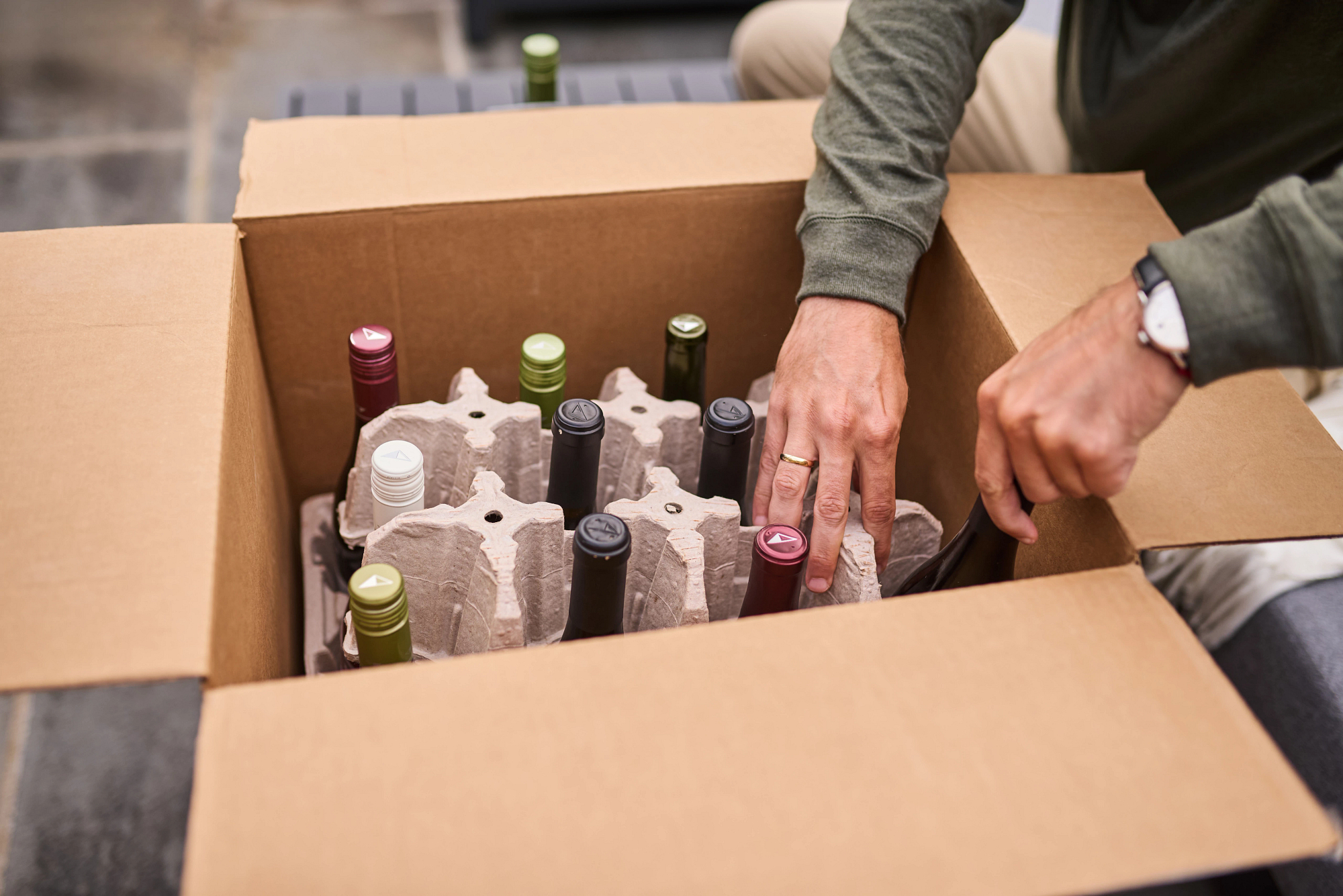 A person opening a wine club shipment from La Crema