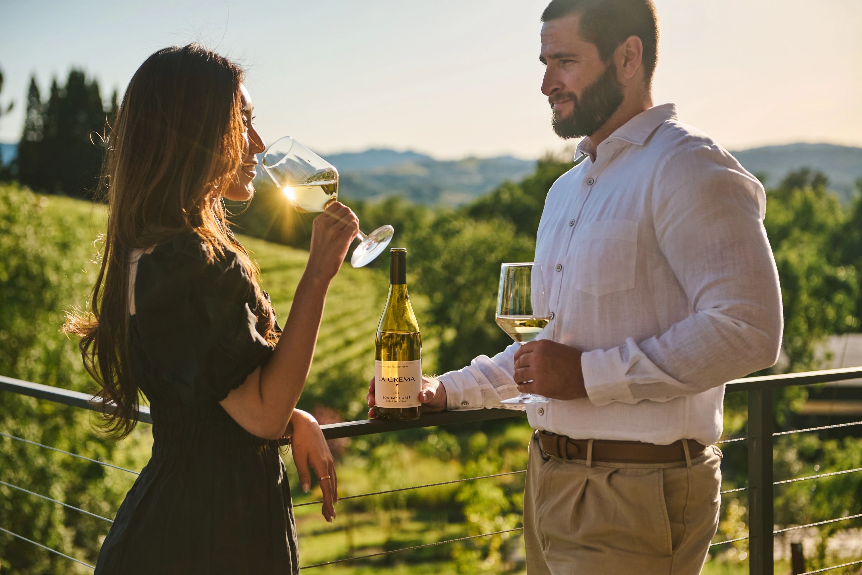 A couple drinking a glass of La Crema Chardonnay outdoors