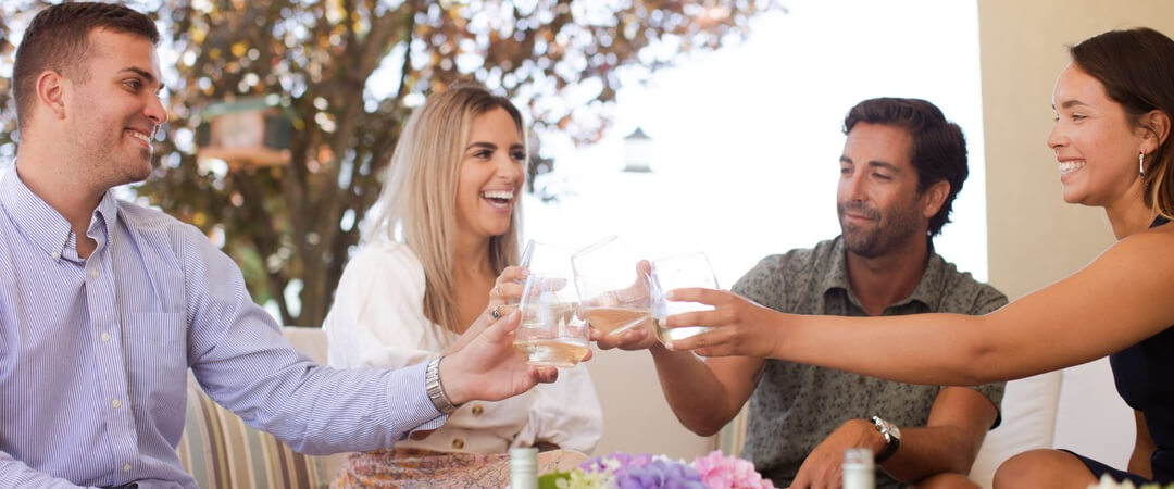 Group cheers wine glasses with white wine