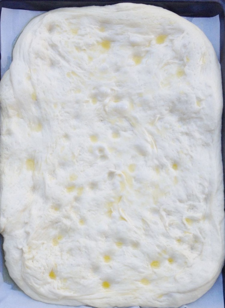 Focaccia spread in a pan