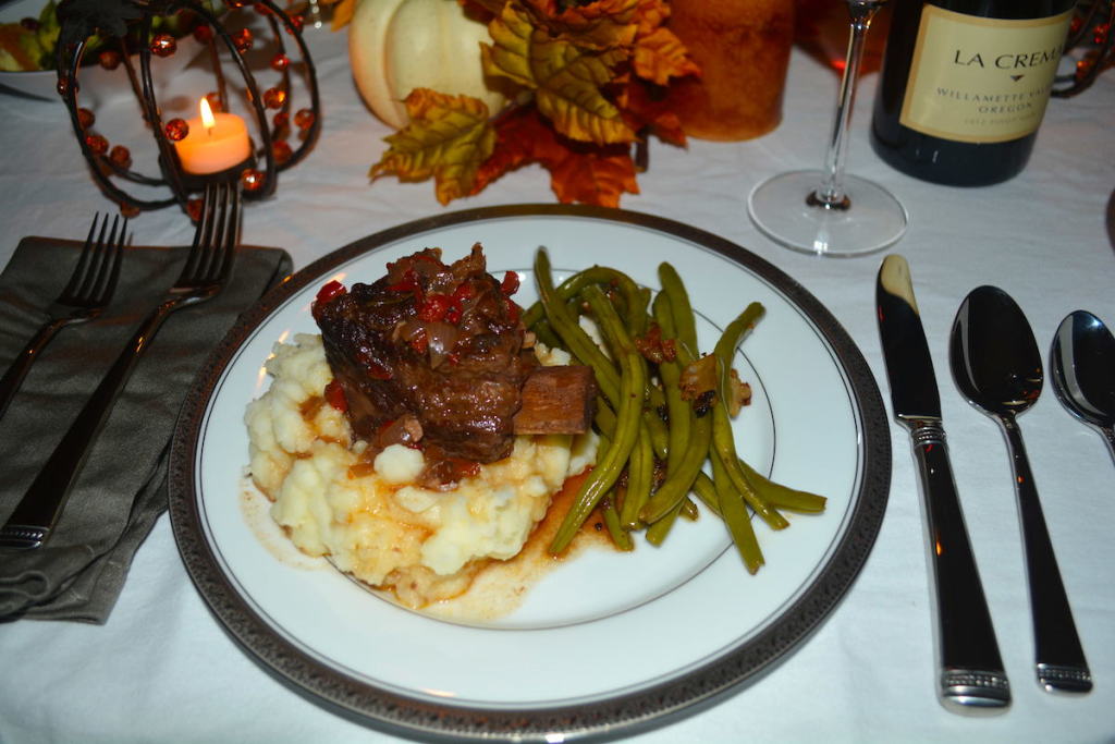 The ribs are laid on top of garlic roasted mashed potatoes to add creaminess to each bite.