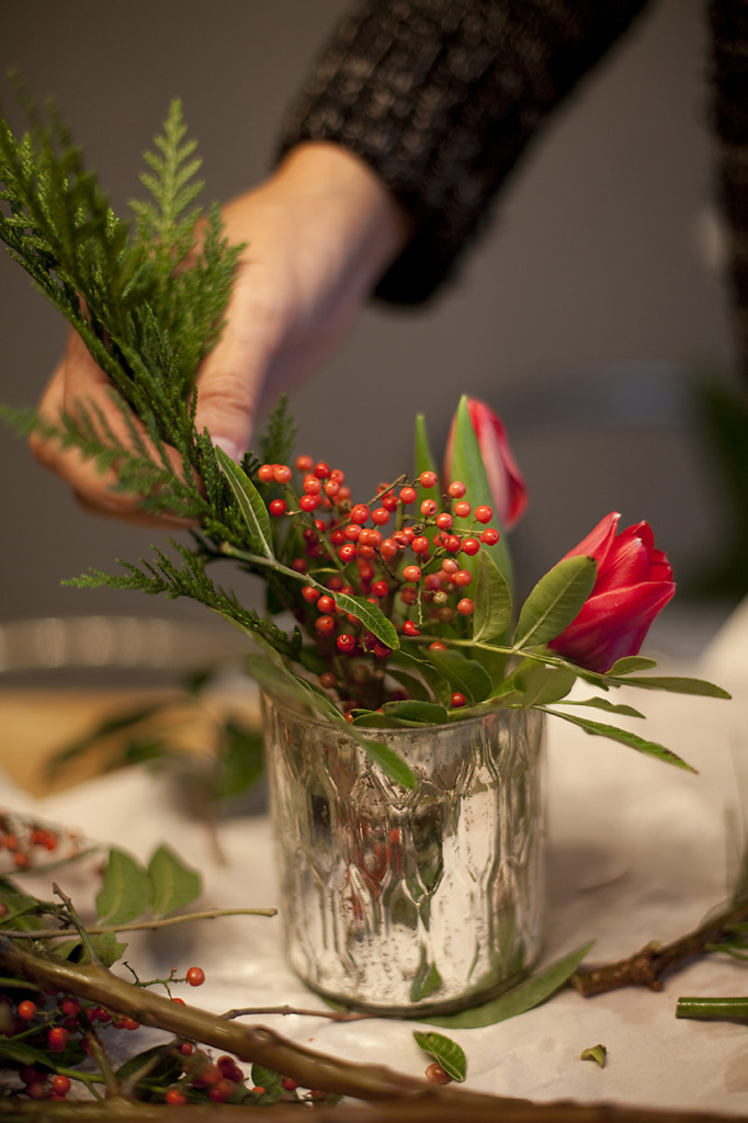 Adding berry sprigs to a natural table runner