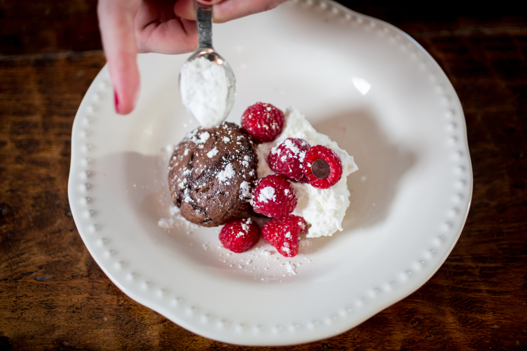 Finish this omemade chocolate cupcake stuffed with berries and cream with some powdered sugar