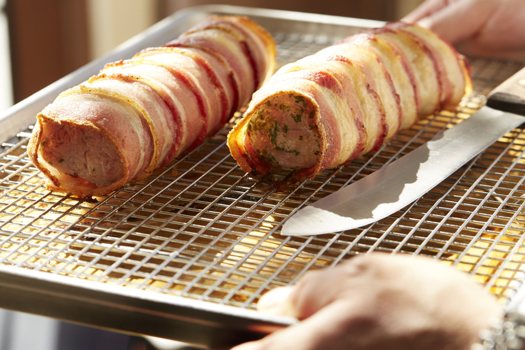 Cooked bacon-wrapped pork tenderloin ready for slicing
