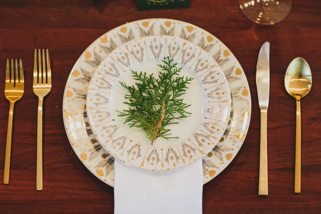 Adding greenery to place settings keeps things festive, a tad rustic, and warm.