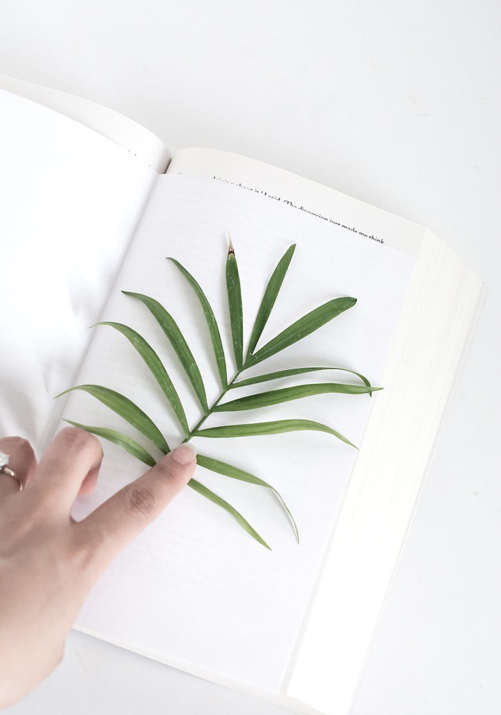 Press the palm leaf in a book to flatten it to create DIY Palm Leaf Napkins
