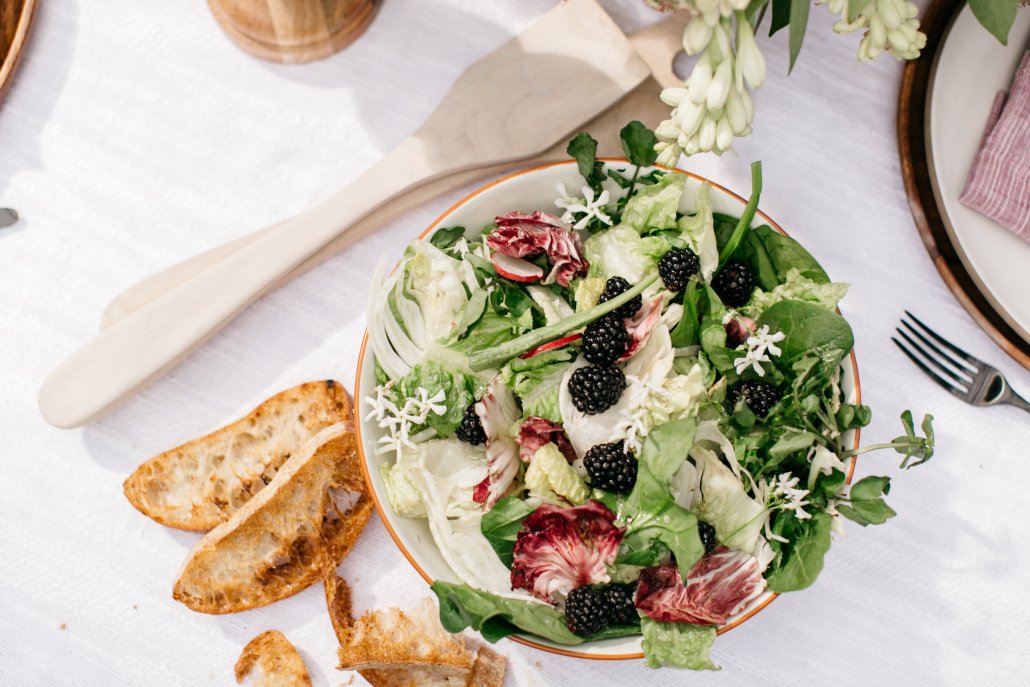 Simple market green salad with fennel, berries and herbs at a low-key dinner party by Camille Styles