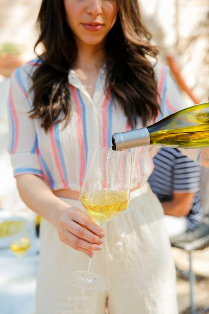 Woman pouring Chardonnay at a Spring BBQ