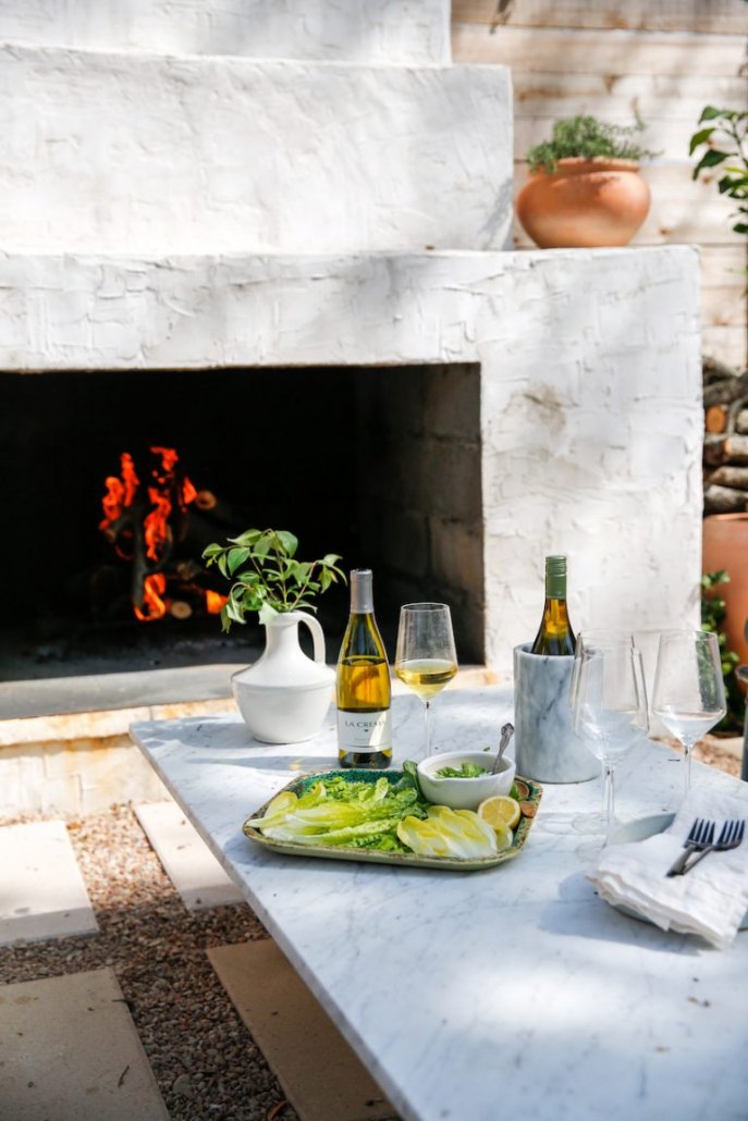 Food and wine in front of a backyard firepit.