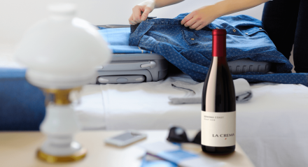 Bottle on Nightstand w/ suitcase on the bed